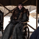 The black-clad Arya, Bran, and Sansa Stark sit stone-faced on a covered dais in the Dragonpit.